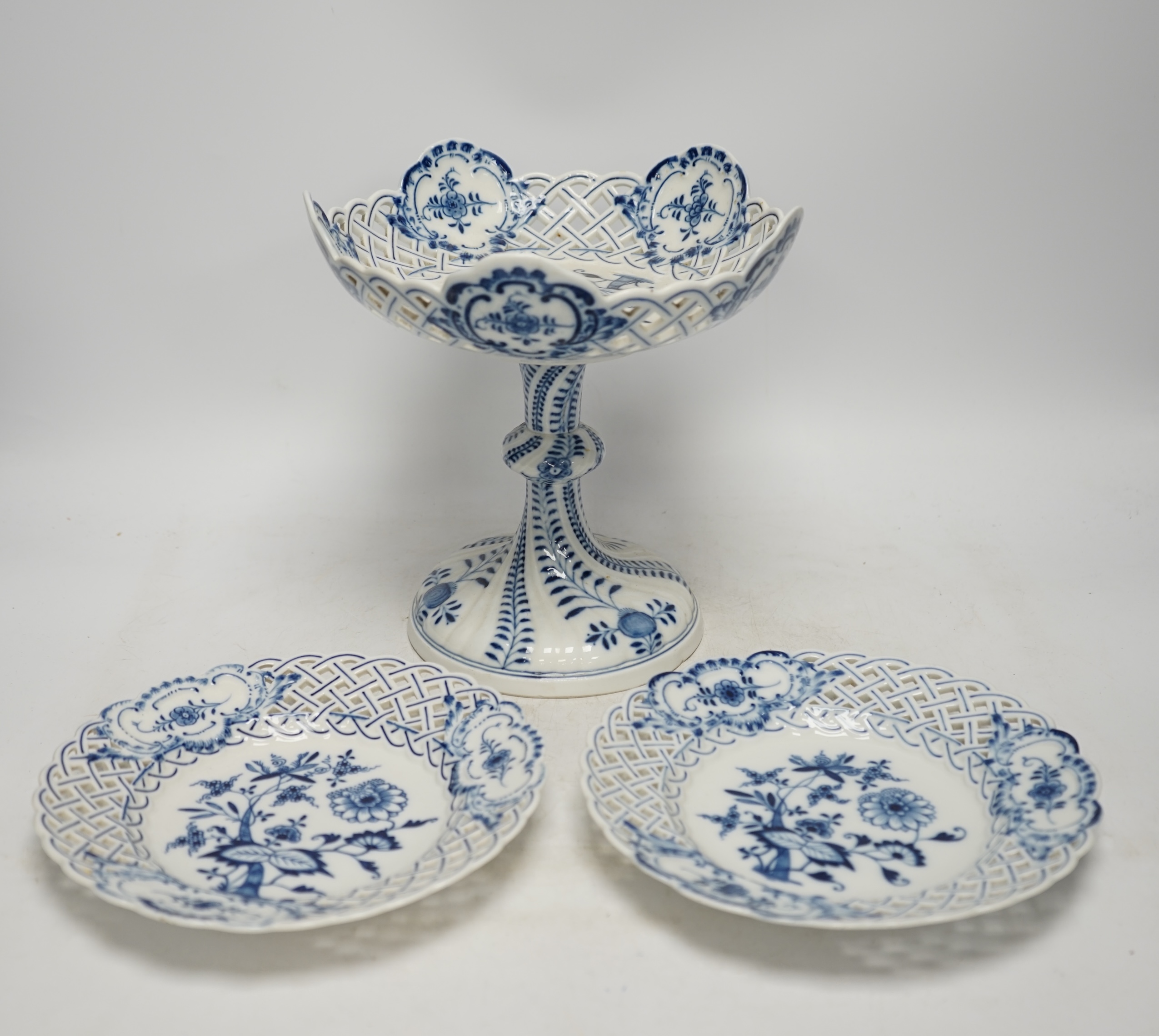 A late 19th Meissen blue and white onion pattern dessert service, consisting of a pair of comports and twelve dishes, all with pierced borders, (14). Condition - poor to good, two plates with pieces of border missing, on